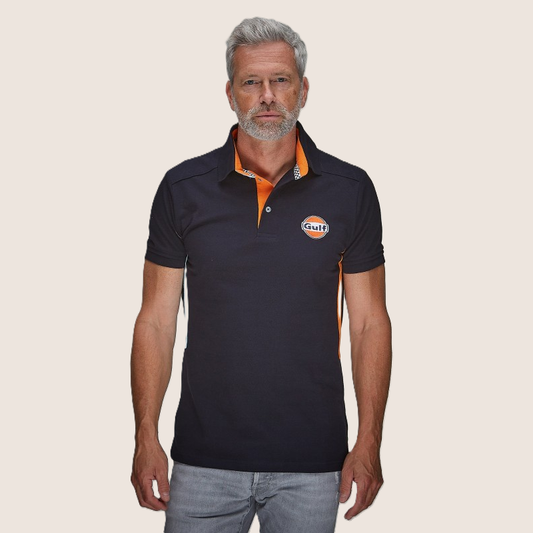 Gulf Side Stripe Polo Navy – Sporty polo i navyblå med ikoniske Gulf-racingstriber langs siden. Komfortabelt bomuldsdesign, perfekt til motorsportsfans og hverdagsbrug.