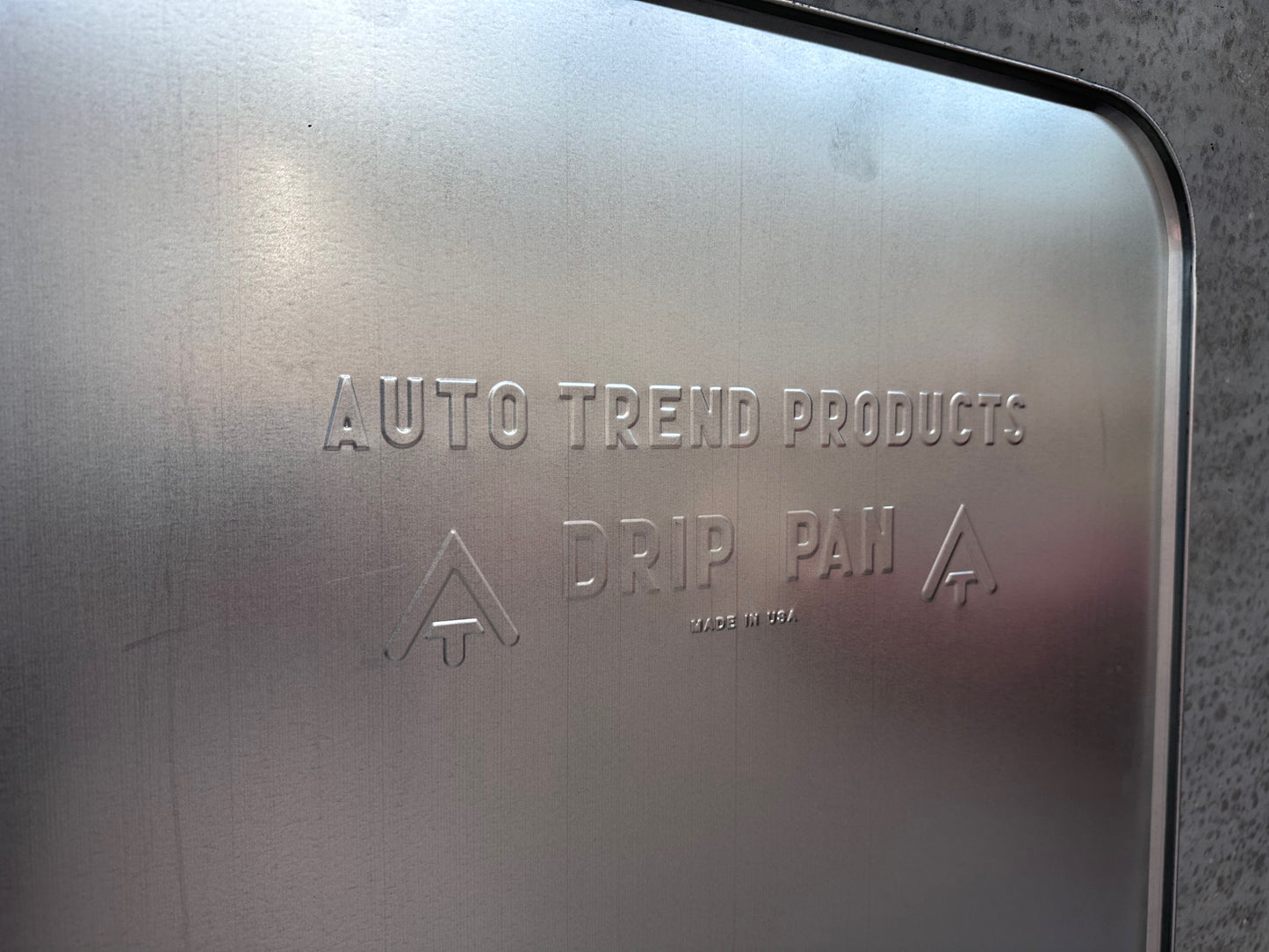 Drypbakke i aluminium 120x64 cm - Zoomet ind på præget tekst drypbakke for at illustrere den minimalistiske stil